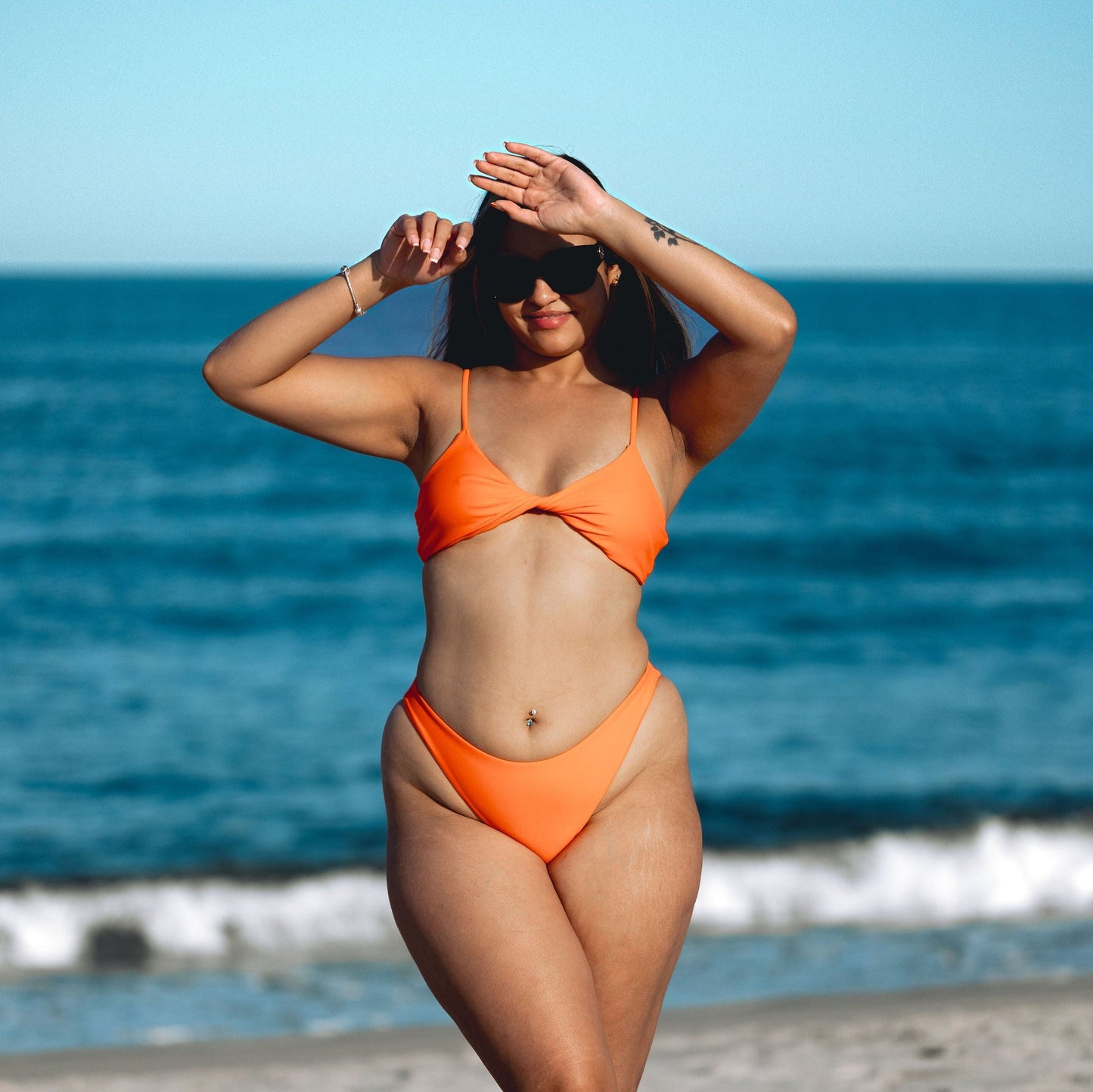 Seamless Orange low scoop top styled with twist front. Complete with adjustable shoulder and back straps paired with cheeky coverage bathing suit bikini bottom